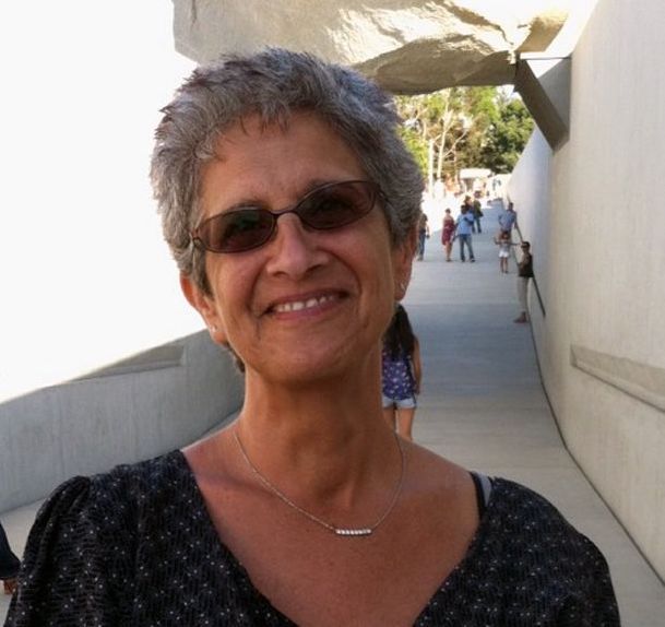 Nina Hyams, wearing sunglasses, smiles in a portrait