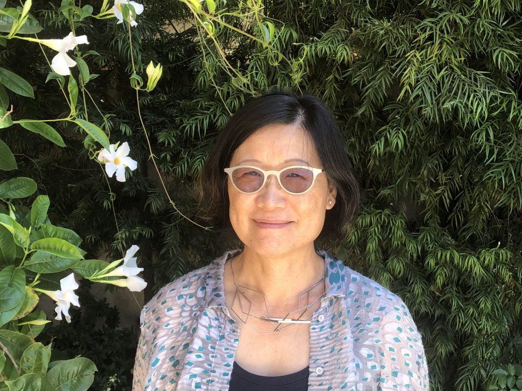 A portrait of Shu-mei Shih against a dark leafy background