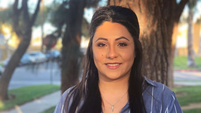 Jazmine Rodriguez smiles at the camera against an outdoor background, lit by the setting sun