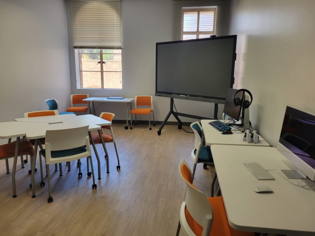 The new Digital Media Lab, a small room with a few tables and chairs, as well as a large screen in one corner