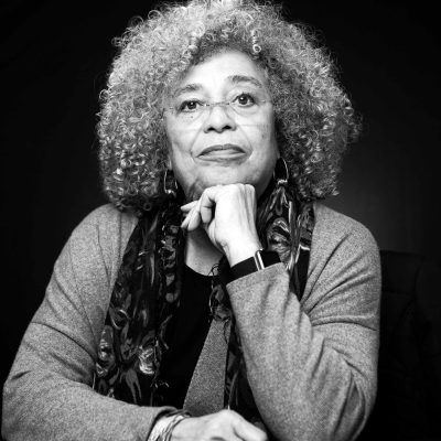 Angela Davis poses with her fist under her chin in a black-and-white portrait