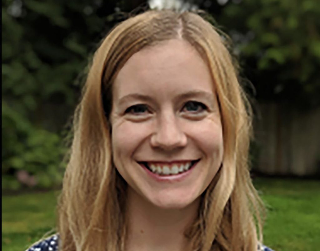 Sarah Beckman smiles against an outdoor backdrop