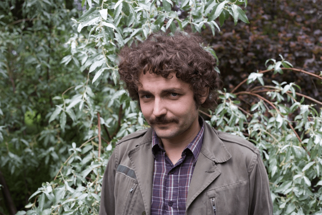 Portrait of Boris Dralyuk in front of greenery