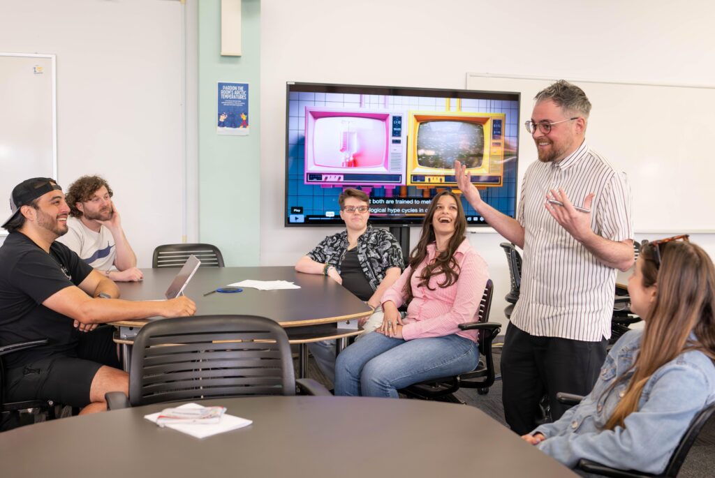 Danny Snelson, standing, center right, with four students seated in classroom