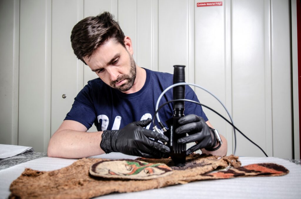 Thiago Puglieri using lab equipment to analyze a Tikuna mask