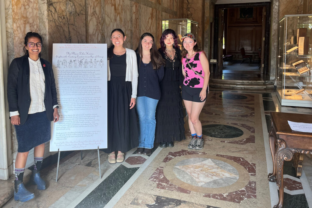 Professor Zirwat Chowdhury (from left) with students Paige Runyan, Bridget Cline, Natalia Castillo and Juno Lumetta inside the Clark Library with a poster about their exhibition