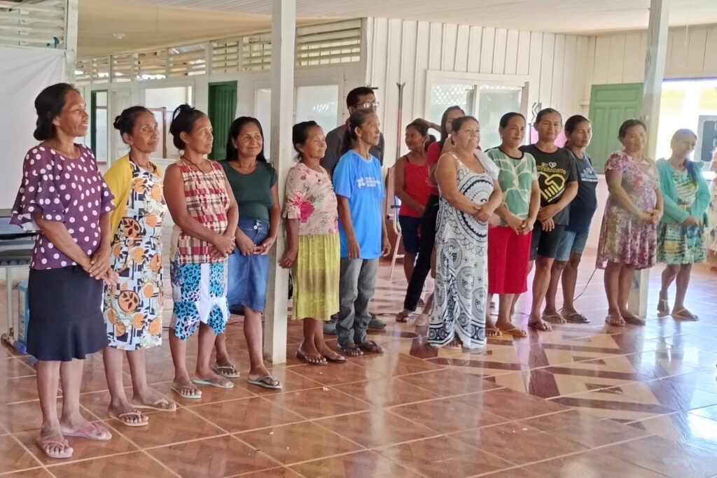 Women from Association of Ticuna Artisan Women, Association of Indigenous Ticuna Women and the Association of Indigenous Women of Porto Cordeirinho standing in a row